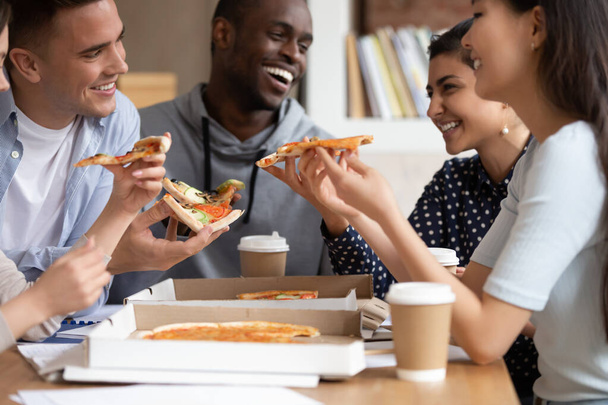 Мультинациональные лучшие друзья студенты едят пиццу во время обеда
 - Фото, изображение