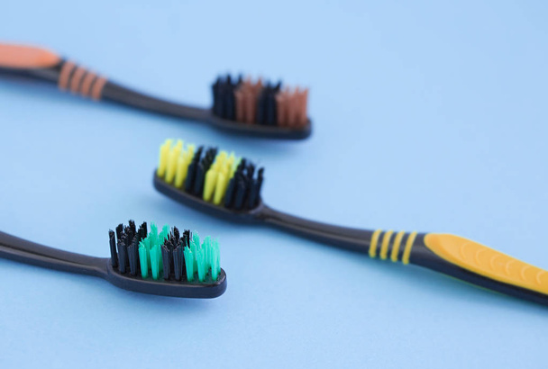 Conjunto de cepillos de dientes multicolores sobre fondo azul
 - Foto, Imagen