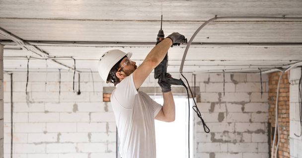Handyman uses jackhammer, for installation, professional worker  - 写真・画像