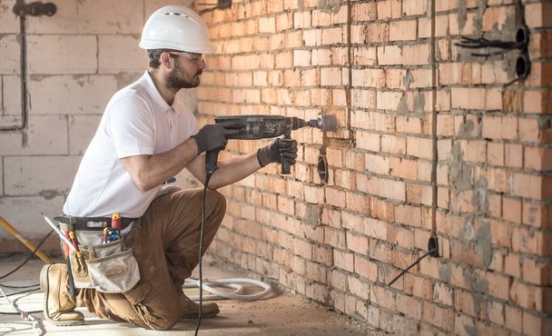 Handyman uses jackhammer, for installation, professional worker  - Zdjęcie, obraz