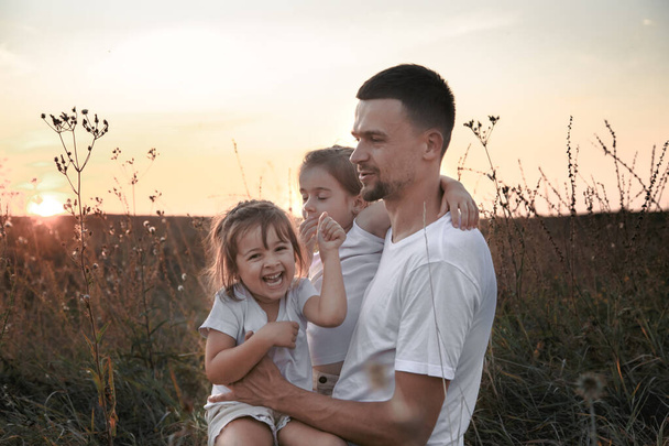 Papa et ses filles dans les champs au coucher du soleil
 . - Photo, image