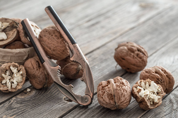 Organic Walnut lies on a wooden background , close-up . - Foto, afbeelding