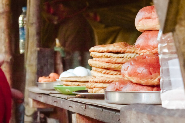 Pan listo para comer, huevo hervido y Roti y otros artículos de comida y bebida se exhiben para vender en un puesto de comida callejera en un mercado local junto a la carretera. Darjeeling, Bengala Occidental, noreste de la India
. - Foto, imagen