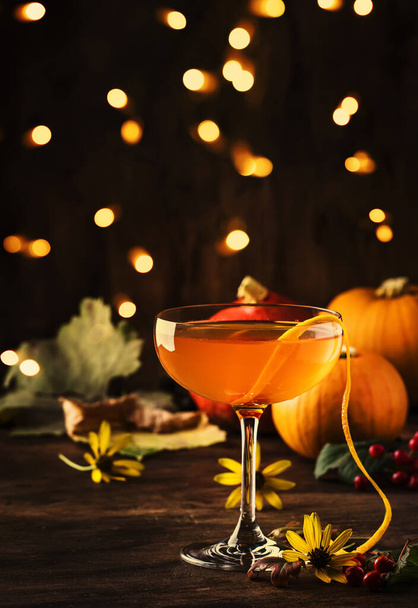 satans-Schnurrhaare, Halloween-Cocktail mit Gin, Wermut, Orangensaft und Likör, dunkler Holzhintergrund mit festlichem Dekor - Foto, Bild