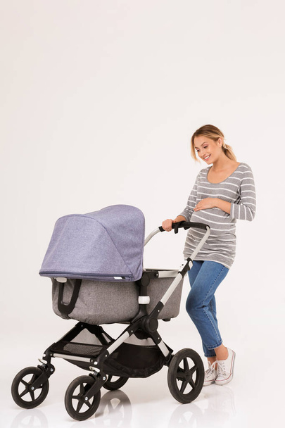 Beauituful young woman standing with a baby pram - Photo, Image