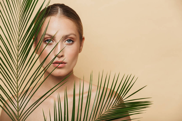 Blonde woman posing naked with green nature leaf plant. - Valokuva, kuva