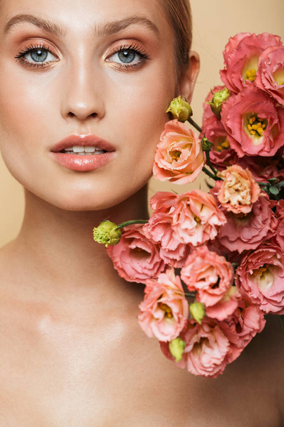Image of beautiful half-naked woman poising at camera with flowers - Photo, Image