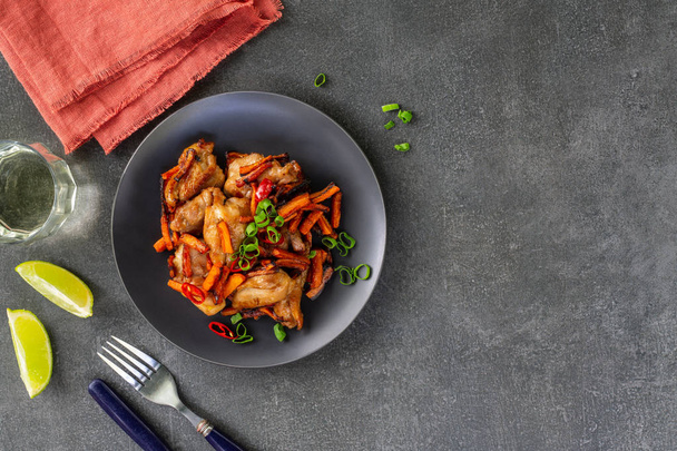 Teriyaki chicken with carrots and green onions and rice wine on a dark background - Fotografie, Obrázek