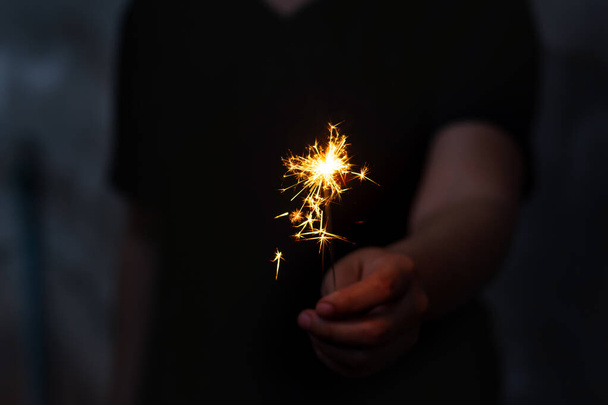 Mulher mão segurando um sparkler ardente
 - Foto, Imagem