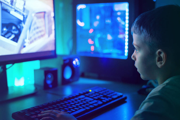 Ragazzo gioco su PC moderno con luci RGB. Scena oscura, primo piano
. - Foto, immagini