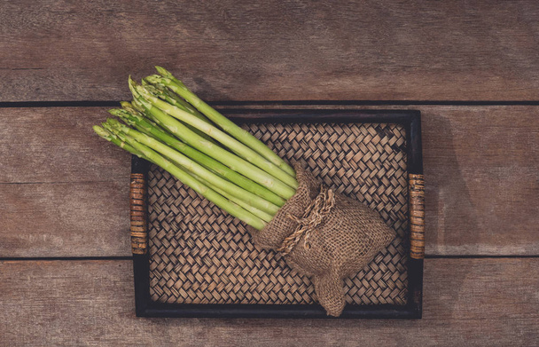 Fresh Asparagus in wooden plate - Фото, изображение