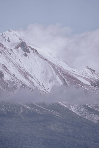 A vertical shot of snowy mountains near the clouds - Fotografie, Obrázek