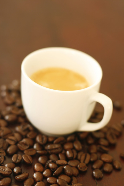 Espresso em xícara cercada por bea de café
 - Foto, Imagem