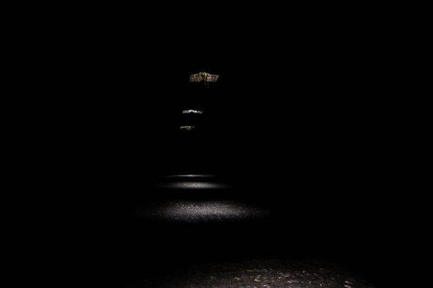 Imagen horizontal de un túnel oscuro con la luz del día entrando a través de los agujeros creando misteriosa imagen
 - Foto, Imagen