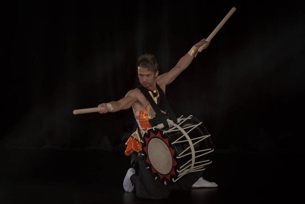 Tambor Taiko con tambor y baquetas en el escenario sobre un fondo negro
 - Foto, imagen