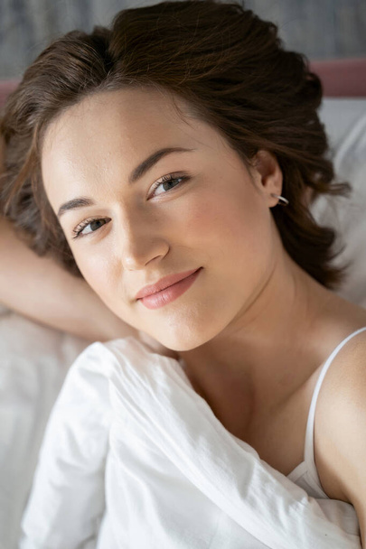 Cute woman in bed smiling at the camera - Valokuva, kuva
