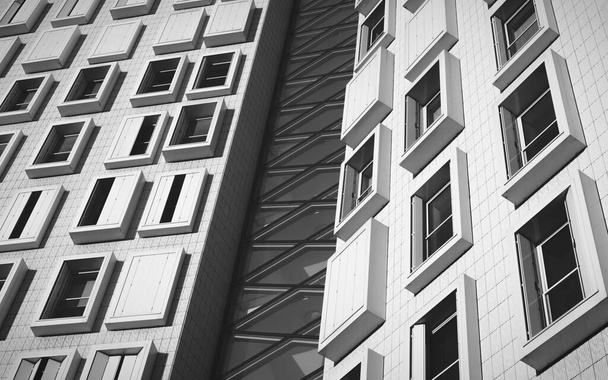 Low angle grayscale shot of a modern white building with rectangular windows - Фото, зображення