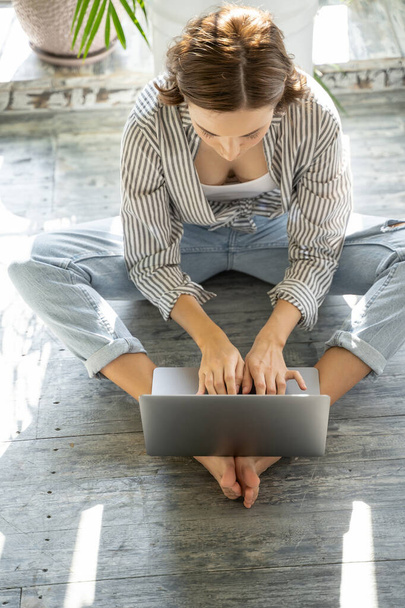 Young lady typing on her computer on the floor - Foto, Bild