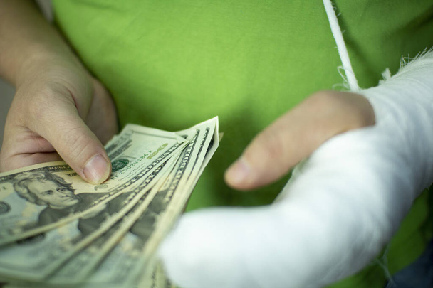 Человек с рукой в гипсе хранит деньги от расходов и расходов на неотложную медицинскую помощь в больнице
 . - Фото, изображение