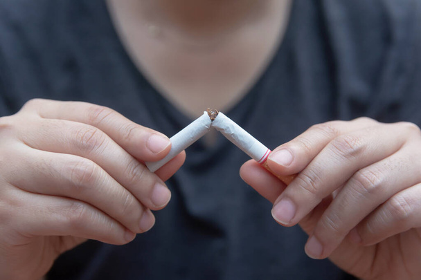 Deja de fumar, manos de mujer rompiendo el cigarrillo con el recorte
 - Foto, imagen