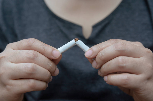 Smettere di fumare, donna mani rompendo la sigaretta con ritaglio
 - Foto, immagini