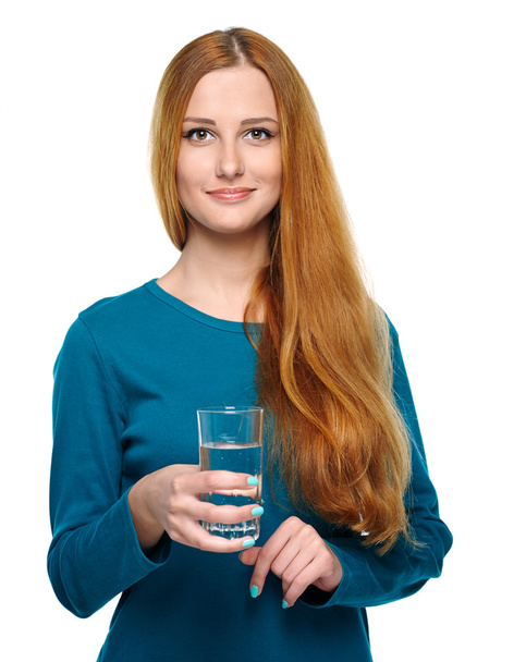 Una joven atractiva con una camisa azul. Toma un vaso de mineral
 - Foto, Imagen