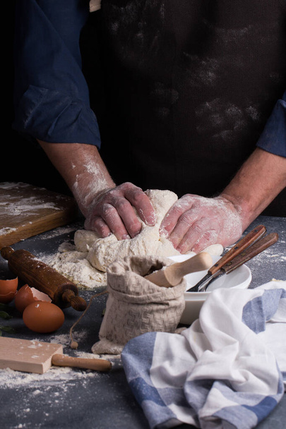 Baker prepares the dough on table. Homemade pastry. - Foto, afbeelding