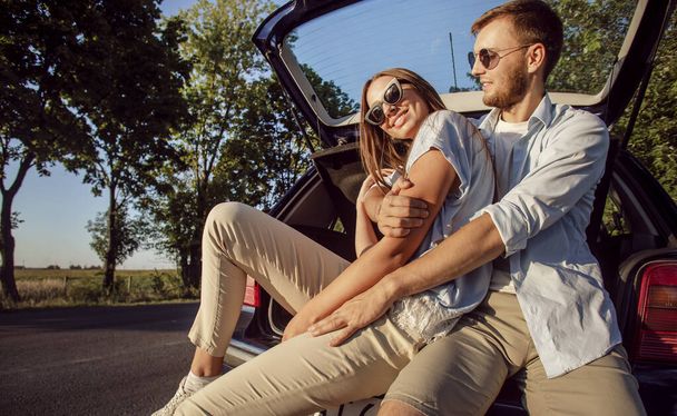 Young Cheerful Couple Hugging in Car Trunk - Foto, Imagem