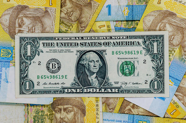 Ein Dollar vor dem Hintergrund einer Griwna. der Dollar aga - Foto, Bild