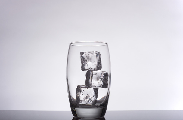 glass with ice cubes on a gradient background - Foto, afbeelding