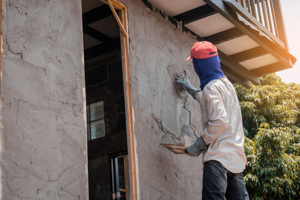 Trabajadores de la construcción que enyesan la pared del edificio usando plast de cemento
 - Foto, imagen