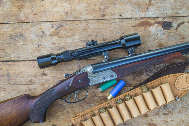 Prachtig jachtgeweer met optisch zicht, jachtriem en karabijn - Foto, afbeelding