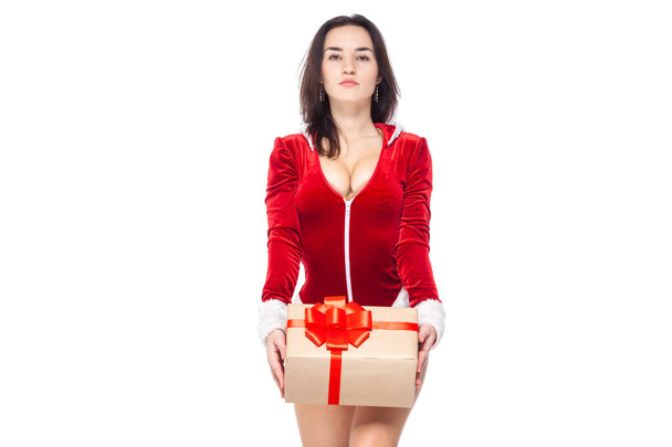 Christmas. Sports fitness girl in red sexy Santa Claus costume holding a gift box tied with a red ribbon with a bow. Isolated on white background. - Foto, imagen