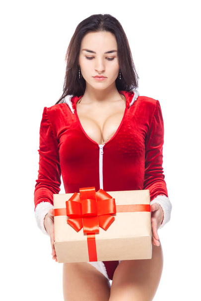 Christmas. Sports fitness girl in red sexy Santa Claus costume holding a gift box tied with a red ribbon with a bow. Isolated on white background. - Foto, immagini