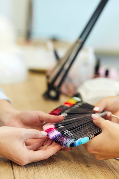 Woman hands choosing nail color - Фото, изображение