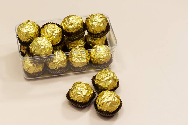 doos van gouden Premium chocolade snoepjes geïsoleerd op roze achtergrond, happy valentine's Day concept - Foto, afbeelding