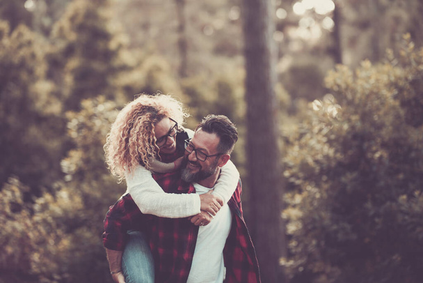 幸せな大人caucasianカップルで関係と愛は森の中で一緒に遊ぶ自然  - 写真・画像
