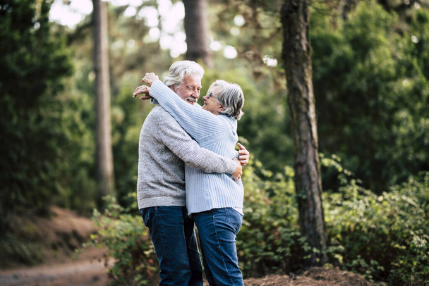 coppia di due anziani che si abbracciano al bosco o alla foresta
  - Foto, immagini