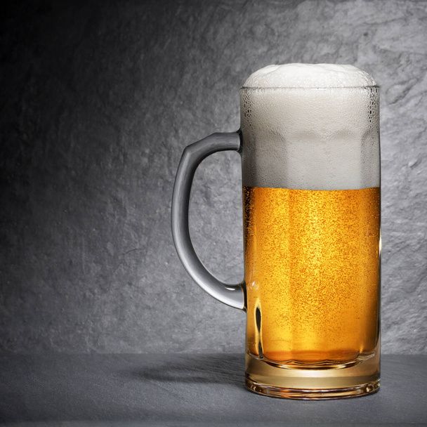 Кружка свежего пива с пеной на черном фоне
 - Фото, изображение