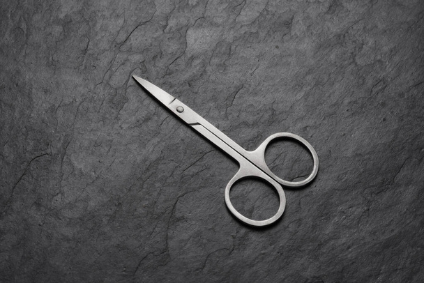 Nail scissors for manicure on black slate background - Photo, Image