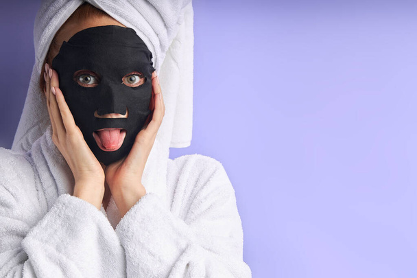 Face care. Beautiful caucasian woman use black mask for face - Foto, immagini