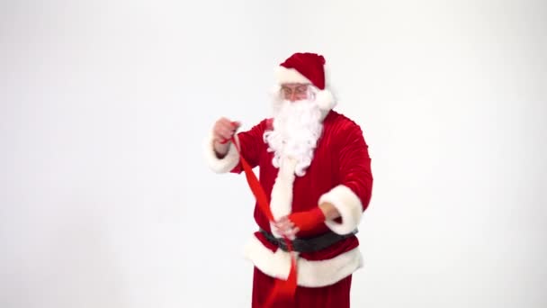Christmas. Santa Claus on a white background reels up red bandages for bokasa and kickboxing. The image of a fighter. - Filmagem, Vídeo