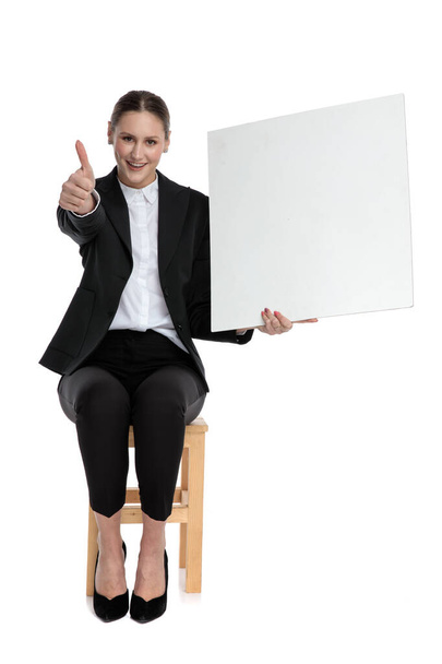 busiensswoman sitting and holding billboard while making ok sign - Photo, Image
