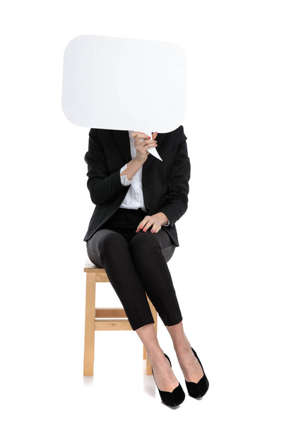 femme d'affaires assise et cachée derrière la bulle de la parole
 - Photo, image