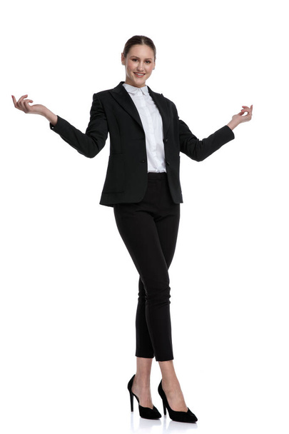mujer de negocios de pie con las piernas cruzadas y saludo con abierto
  - Foto, Imagen