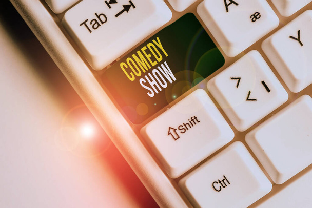 Handwriting text writing Comedy Show. Concept meaning Funny program Humorous Amusing medium of Entertainment White pc keyboard with empty note paper above white background key copy space. - Photo, Image
