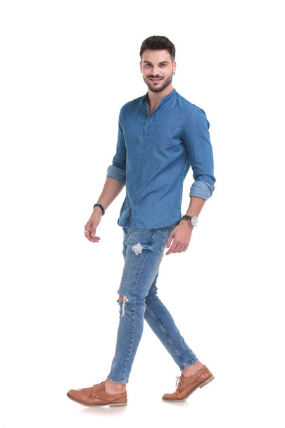 Päättäväinen rento mies kävelee yllään sininen paita
 - Valokuva, kuva