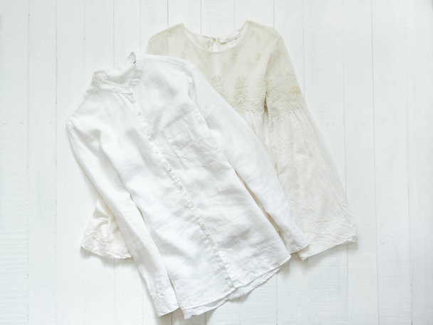 Κεντημένη μπλούζα και λευκό πουκάμισο σε λευκό φόντο. Έννοια ενδυμάτων - Φωτογραφία, εικόνα