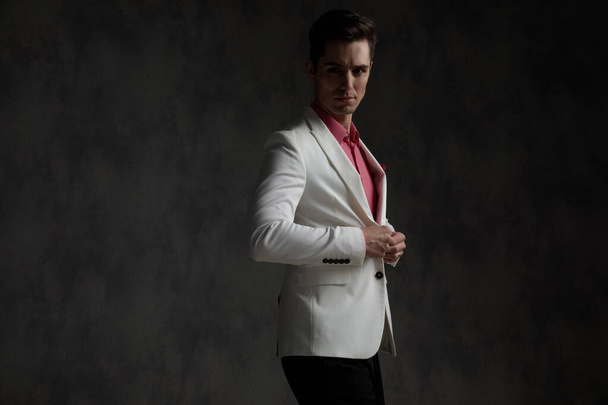 Side view of a attractive elegant man unbuttoning his jacket - Photo, Image