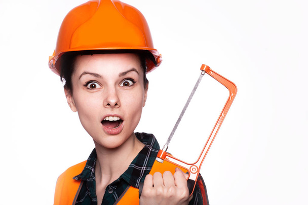 beautiful young girl worker in a helmet holds a screwdriver in his hand - Фото, изображение